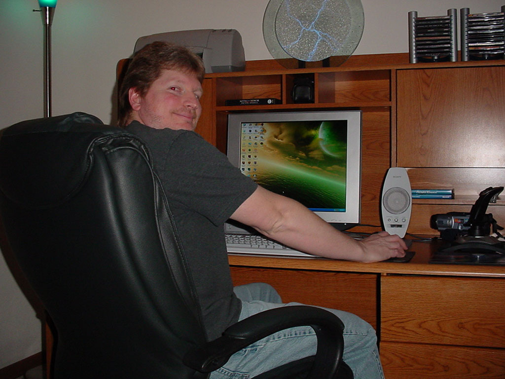 Photo of Richard C. in front of his computer at his home